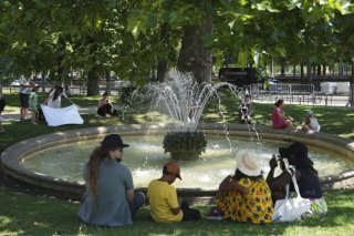 Des personnes cherchent un peu de fraîcheur au jardin des Tuileries à Paris, où le mercure devrait monter jusqu'à 38 degrés mardi. KEYSTONE/AP/Christophe Ena